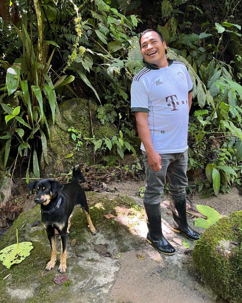 Paraecologist Olger Kitiar stands at the riverside after hiking through montane rainforest to check a camera trap tucked deep in the forest.