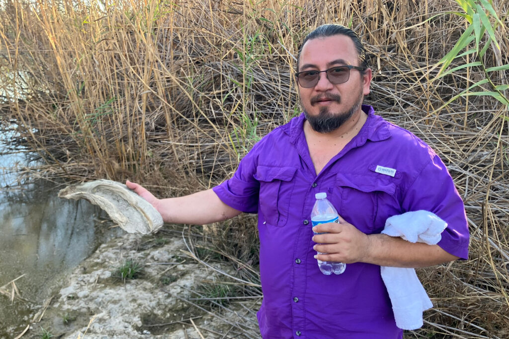Juan Moreno holds one of the fossils during a walk on the river. Credit: Martha Pskowski/Inside Climate News