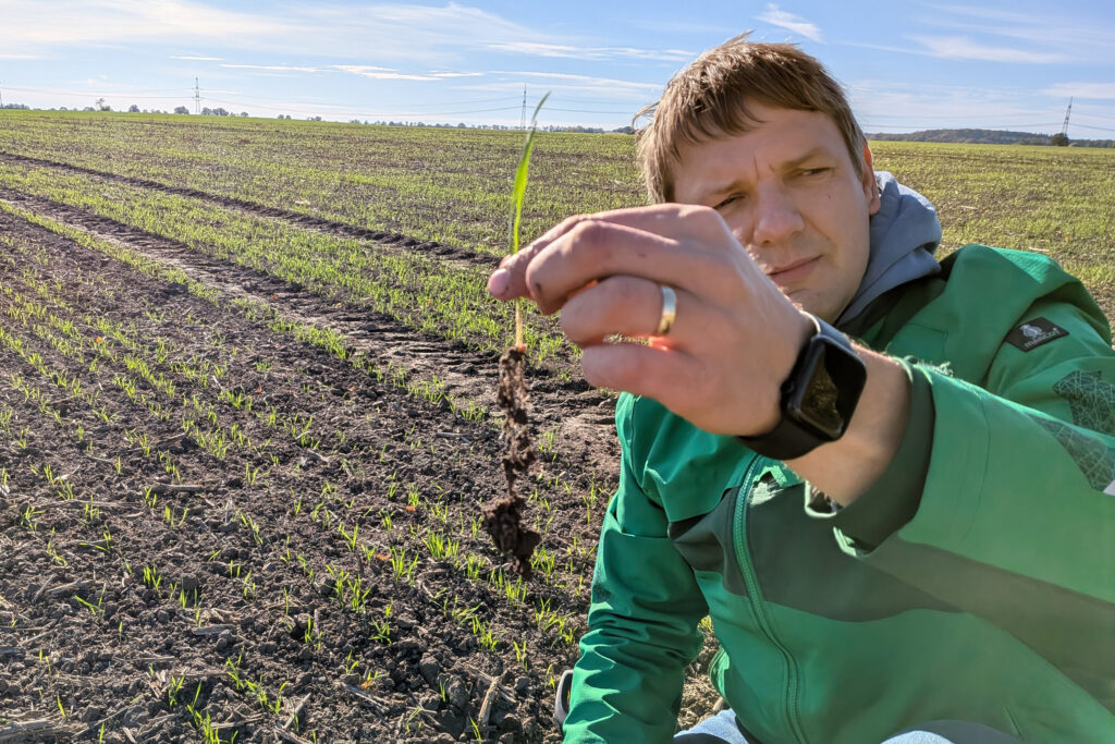 Stefan Bernickel holds a clump of soil with an earthworm to demonstrate his farm’s soil health in Gramzow, Brandenburg. Credit: Aram Zucker-Scharff