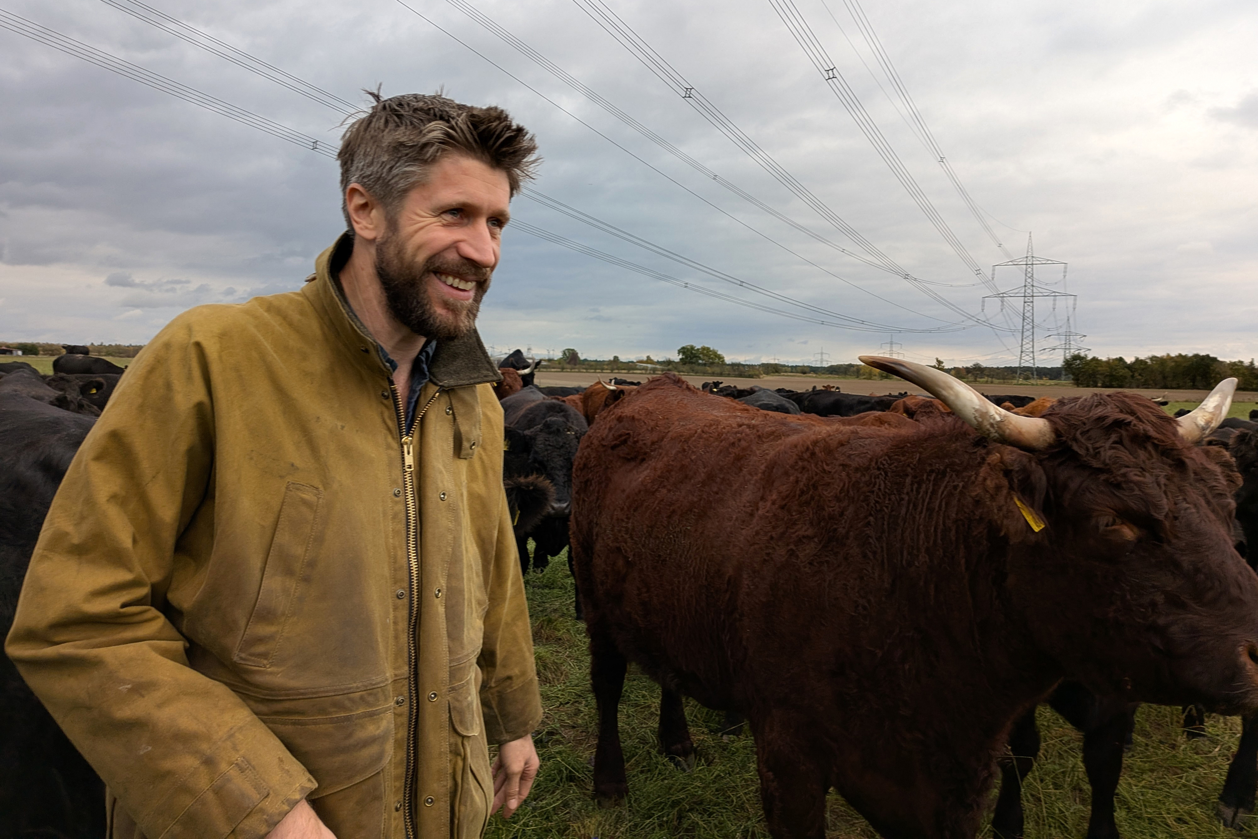 Benedict Bösel is surrounded by some of his 320 cows on his family farm in Germany. Credit: Aram Zucker-Scharff