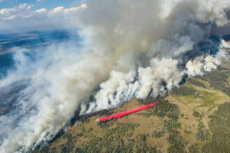 An air tanker works to slow the spread of the Dollar Lake Fire as it burns through Wyoming in August 2025. Credit: Kris Bruington/BLM