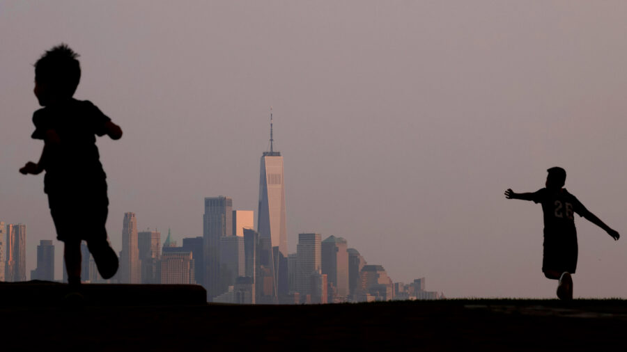 Children play in a park as the skyline of New York City is shrouded by a hazy sky on July 18, 2023. Credit: Gary Hershorn/Getty Images