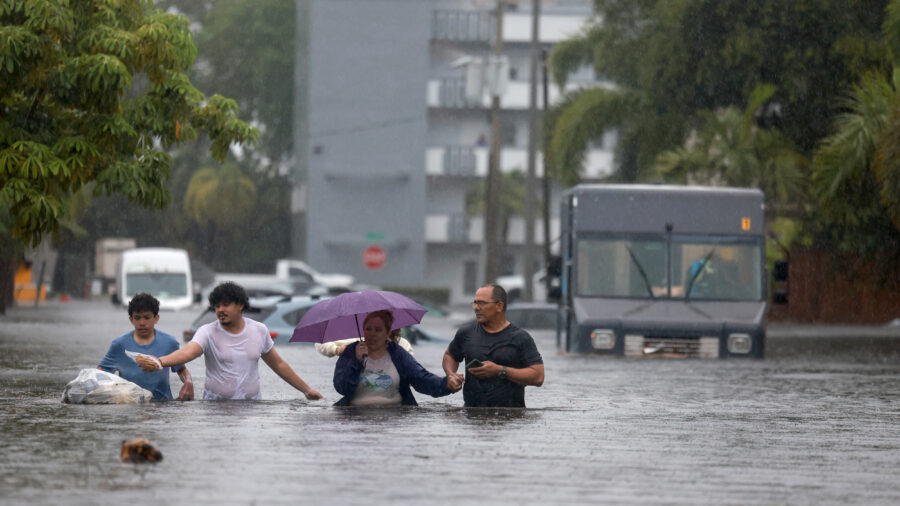 People walk through as flooded street as they evacuate during a storm on June 12, 2024, in Hollywood, Fla. Credit: Joe Raedle/Getty Images