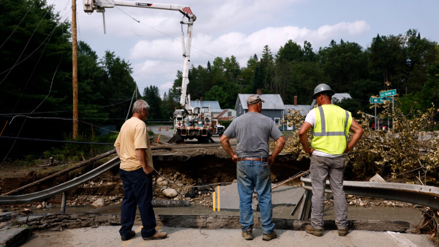 Workers survey the damage after flash floods collapsed a bridge in St. Johnsbury, Vt. Credit: Danielle Parhizkaran/The Boston Globe via Getty Images