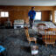 Misty Cheng looks at flood damage to her home in Wrightwood, Calif., on Dec. 25, 2025. Credit: Eric Thayer/Los Angeles Times via Getty Images