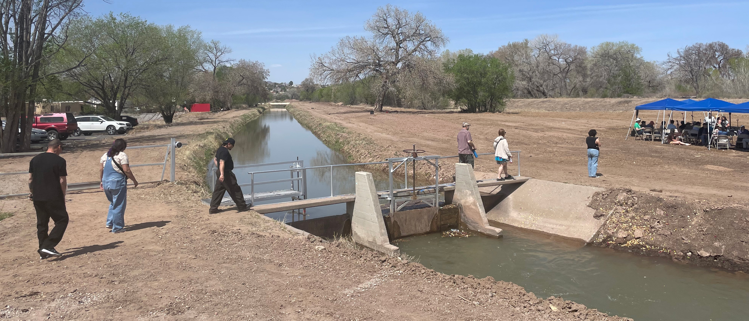 People cross a bridge over the Atrisco Acequia Madre during the Primera Agua event in Albuquerque. Credit: Tina Deines/Inside Climate News