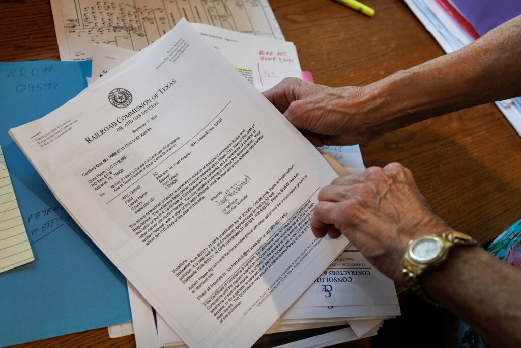 Jackie Chesnutt looks through documents pertaining to oil wells located on her property, many of which have leaked, on Nov. 18, 2025.