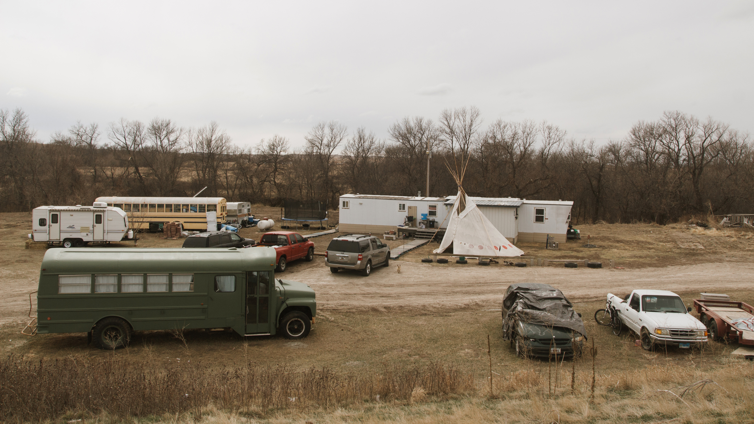 A home on the Pine Ridge Reservation in South Dakota, where a tipi stands alongside trailers and parked vehicles—a blend of tradition and modern life in a region shaped by decades of underinvestment. Credit: Carla Samon Ros/CJI