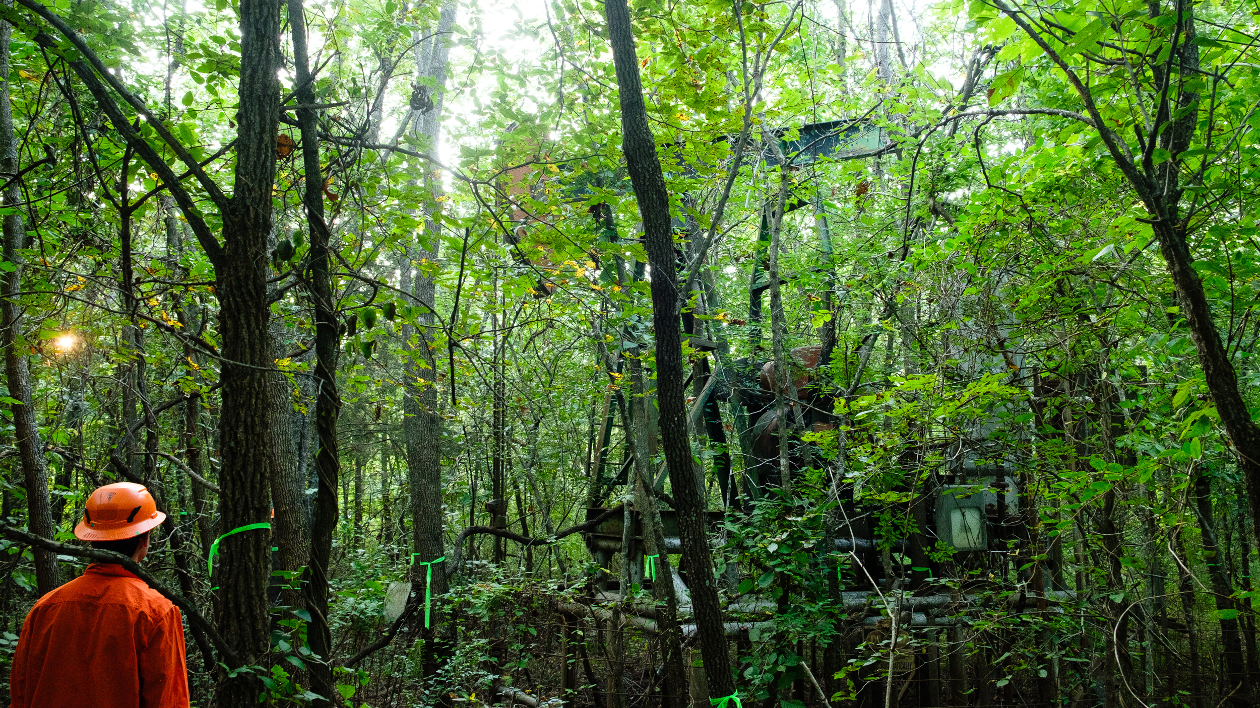 A pump jack elevated above the Deep Fork’s flood level sits near a well slated to be plugged by Well Done.