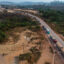Trucks drive along the BR-163 highway through the Amazon rainforest in Pará, Brazil. Credit: Nelson Almeida/AFP via Getty Images