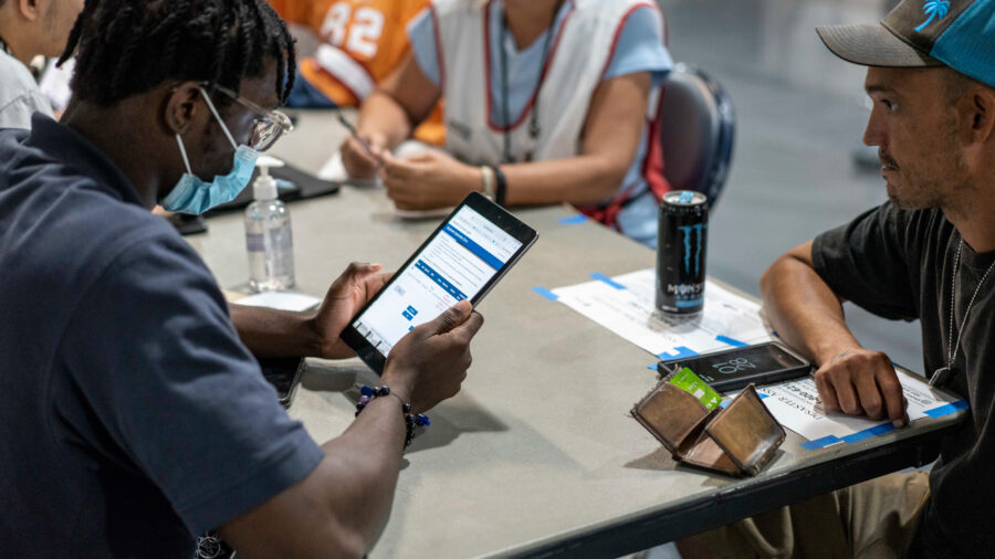 FEMA representatives take information from people displaced by Hurricane Ian at a shelter in Estero, Fla. Credit: Thomas Simonetti for The Washington Post/Getty Images