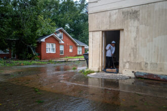 A woman sweeps floodwater out of her home on Sept. 11, 2024, in Houma, La. Credit: Brandon Bell/Getty Images