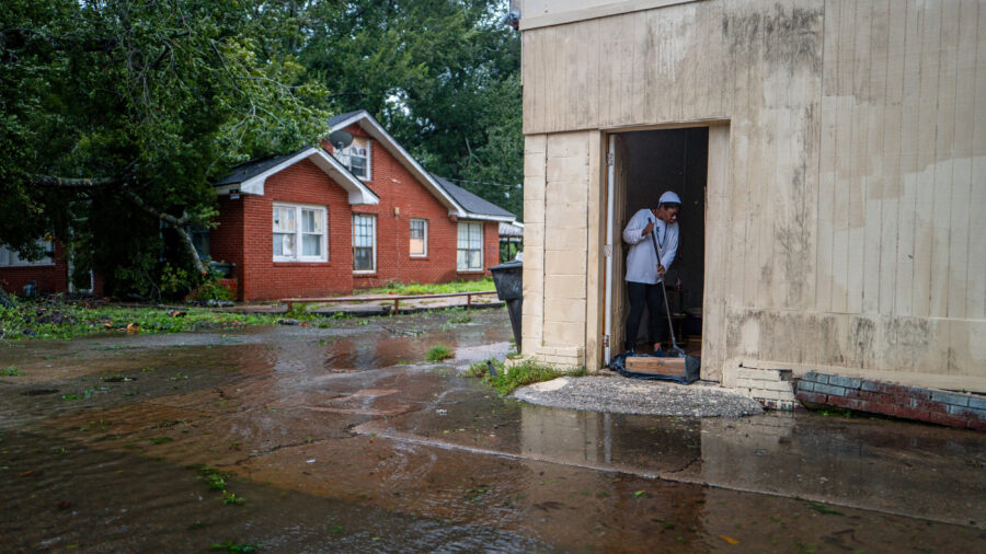 A woman sweeps floodwater out of her home on Sept. 11, 2024, in Houma, La. Credit: Brandon Bell/Getty Images