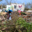 A woman clears debris near a damaged building on Oct. 29, 2025, following the passage of Hurricane Melissa in Black River, Jamaica. Credit: Ricardo Makyn/AFP via Getty Images