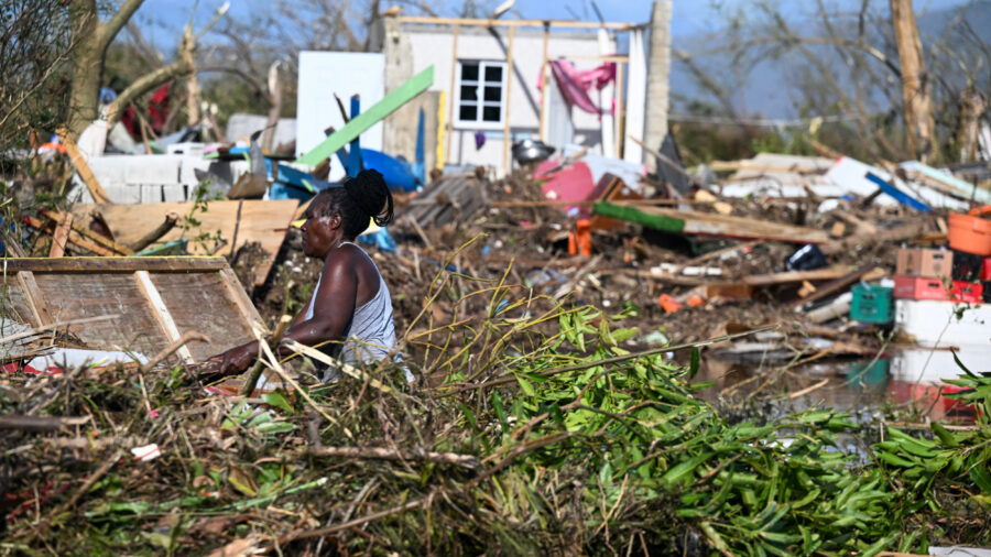A woman clears debris near a damaged building on Oct. 29, 2025, following the passage of Hurricane Melissa in Black River, Jamaica. Credit: Ricardo Makyn/AFP via Getty Images