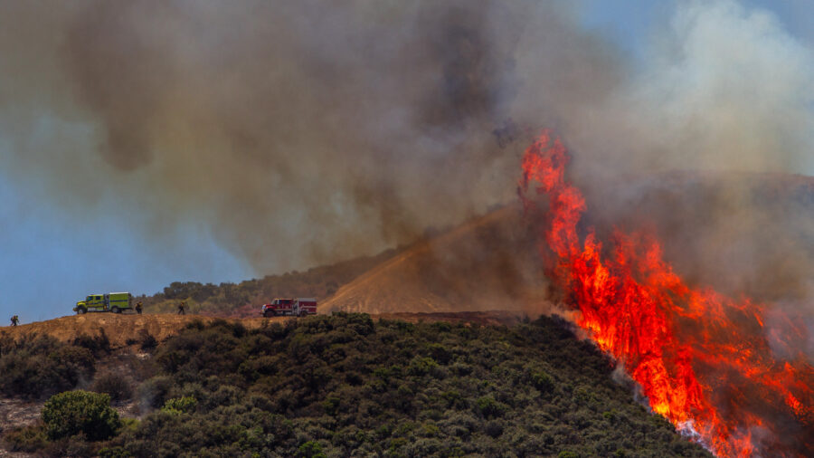 Firefighters work to combat a hotspot in the hills while the Sandy Fire continues to burn near a residential area on Wednesday in Simi Valley, Calif. Credit: Apu Gomes/AFP via Getty Images