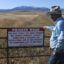 Fifth-generation Montanan Brad Wilson stands beside a dirt road that leads to a century-old public trail that was abandoned by the U.S. Forest Service as part of a controversial land swap with the Yellowstone Club—an exclusive mountaintop retreat for the megarich. Credit: Evan Simon/Floodlight