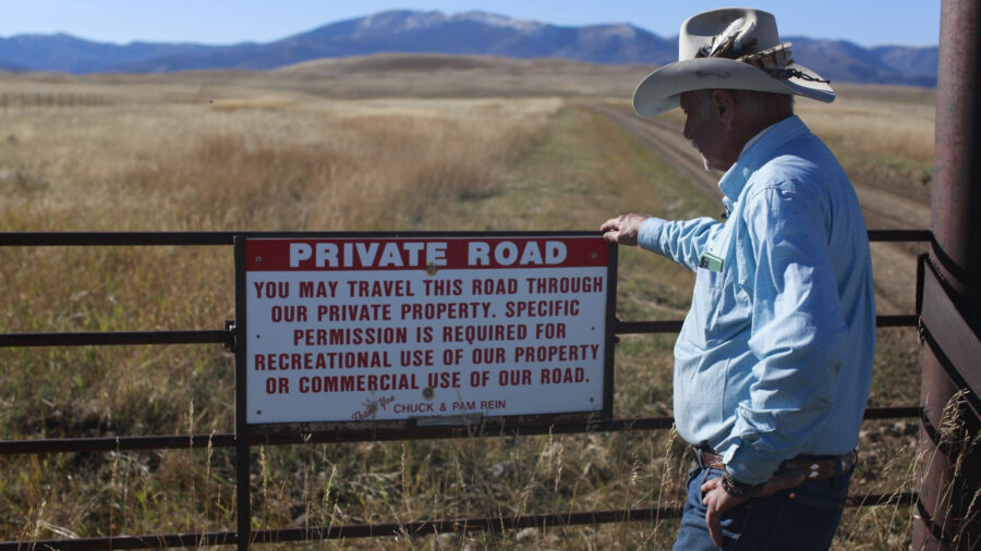 Fifth-generation Montanan Brad Wilson stands beside a dirt road that leads to a century-old public trail that was abandoned by the U.S. Forest Service as part of a controversial land swap with the Yellowstone Club—an exclusive mountaintop retreat for the megarich. Credit: Evan Simon/Floodlight