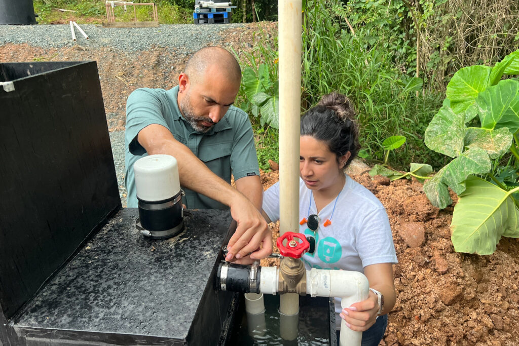 Francisco Guzmán Alvarado (left) and Aminta Nuñez work on the water filter installation at Plenitud in December.