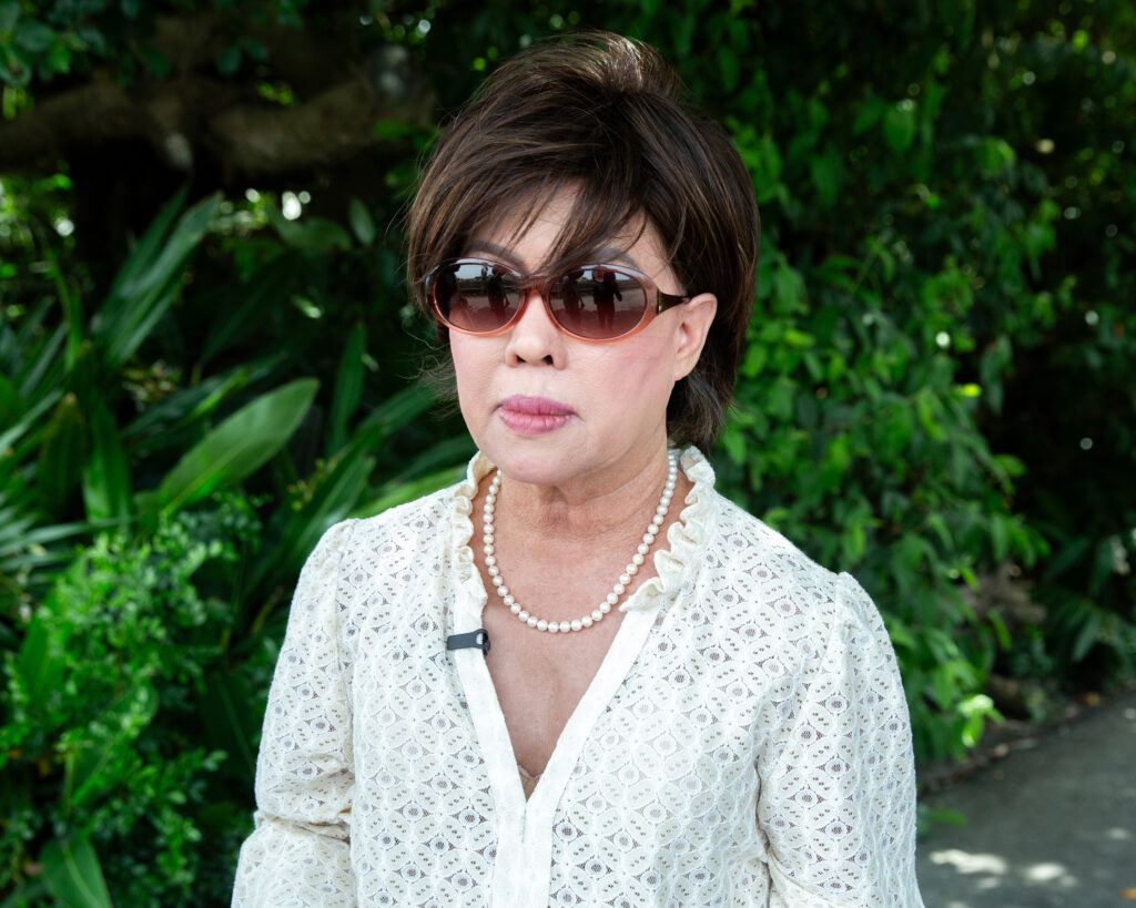 Nancy Bui pauses in the shade in a village of Taiwan’s Yunlin County during a bus tour with other activists on May 26.