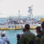 Fishers wave from onboard a Chinese-flagged squid jigger. Credit: Environmental Justice Foundation