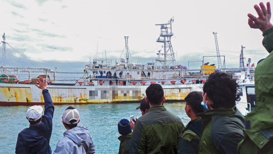 Fishers wave from onboard a Chinese-flagged squid jigger. Credit: Environmental Justice Foundation