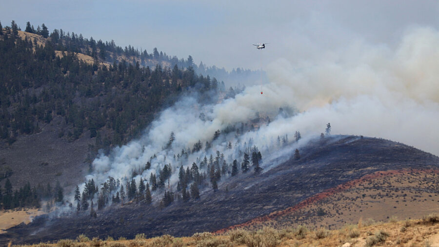 A helicopter crew battles a wildfire near Kalispell, Mont., in August 2022. Credit: Don and Melinda Crawford/Universal Images Group via Getty Images