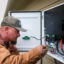 A worker with Base Power installs a home battery system that can send energy back to the grid during peak times in Houston on Feb. 18, 2025. Credit: Brett Coomer/Houston Chronicle via Getty Images