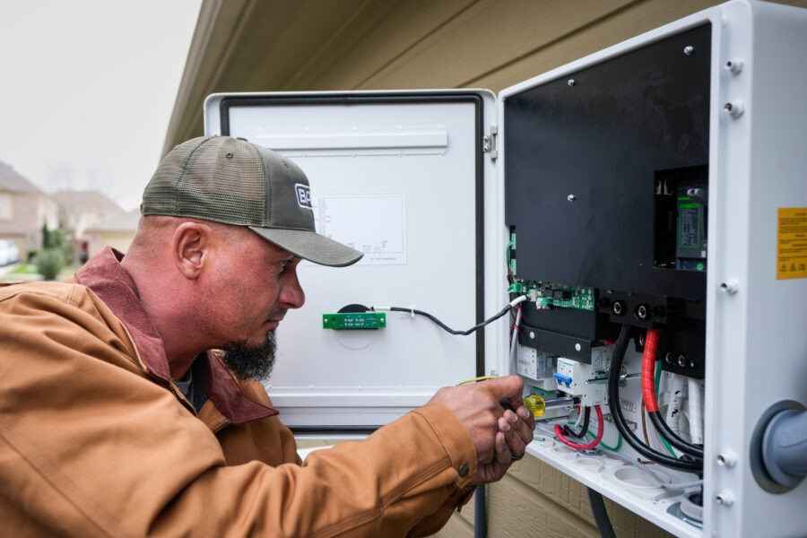 A worker with Base Power installs a home battery system that can send energy back to the grid during peak times in Houston on Feb. 18, 2025. Credit: Brett Coomer/Houston Chronicle via Getty Images