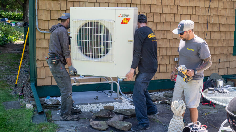 HVAC technicians install a heat pump system at a home in Charlotte, Vt., on July 21, 2025. Credit: Robert Nickelsberg/Getty Images