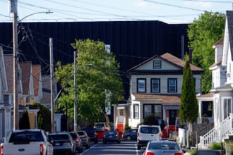Lowell, MA - May 12: The view down a street in Lowell, Mass., where a data center looms behind residential housing on May 12. Credit: Danielle Parhizkaran/The Boston Globe via Getty Images
