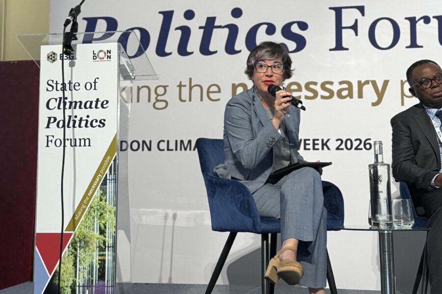 Columbia Mayor Barbara Buffaloe is sitting and speaking into a microphone on the stage, a sign behind and in front of her that says, "State of Climate Politics Forum."