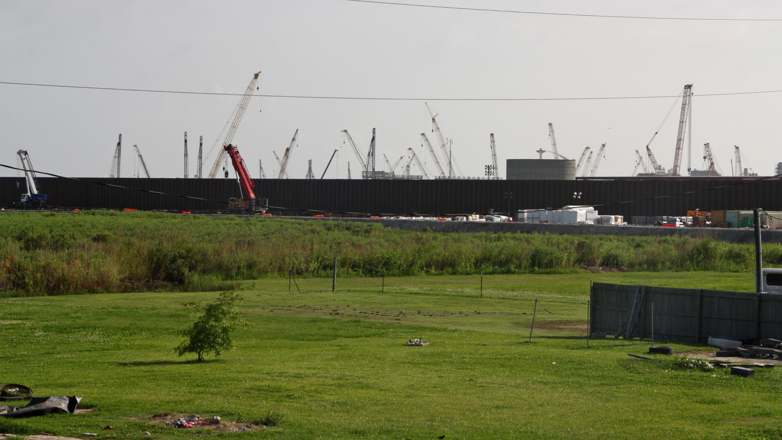 Sherry Peshoff’s front door used to look onto grasslands where she rode horses as a child. Now she sees the 31.5-foot steel fence that surrounds a new LNG terminal. Credit: Nicholas Kusnetz/Inside Climate News