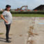 Sherry Peshoff stands on a slab where a home use to sit next to the perimeter wall of Venture Global’s CP2 terminal in Cameron, La. Credit: Nicholas Kusnetz/Inside Climate News