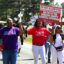 Members of the Lumberton Alumnae Chapter of the Delta Sigma Theta Sorority and Las Amigas Incorporated march along Britt Road on April 18 in St. Pauls, N.C., against the Robeson County Landfill expansion. Credit: Morgan Casey
