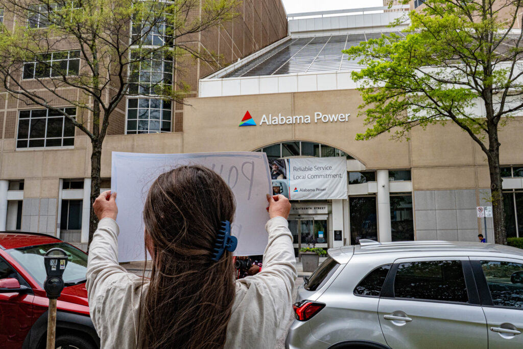 A protester holds a sign in front of Alabama Power’s Birmingham headquarters after the passage of the PSC restructuring law. Credit: Lee Hedgepeth/Inside Climate News