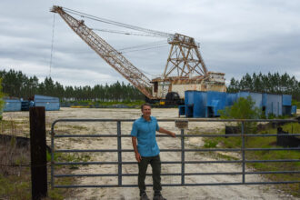 Stacy Funderburke stands in front of a dragline on the southeastern edge of the Okefenokee National Wildlife Refuge in Georgia. Credit: Ryan Krugman/Inside Climate News