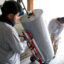 Technicians remove a natural gas water heater from a home to be replaced with an electric heat pump. Credit: Bastien Inzaurralde/AFP via Getty Images