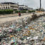 People ride past a drain clogged with plastic waste along a roadside in Karachi, Pakistan, on Aug. 24, 2025. Credit: Asif Hassan/AFP via Getty Images