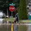 A father helps his son walk over a path made of sandbags following severe flooding on Dec. 12, 2025, in Burlington, Wash. Credit: Natalie Behring/Getty Images