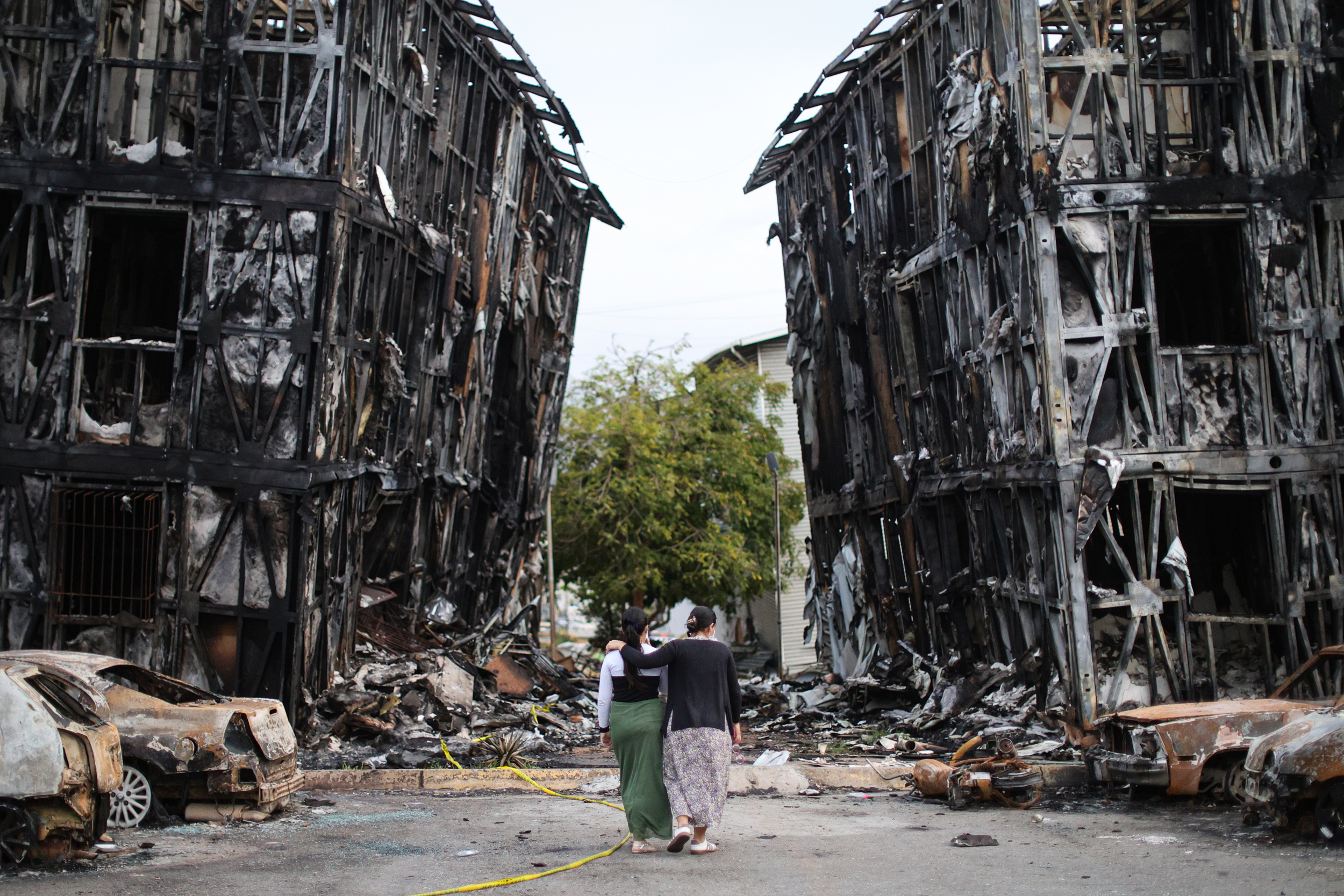People look at burned-down buildings in Caracas, Venezuela, on June 30 after a 7.2-magnitude earthquake struck the region. Credit: Jesus Vargas/Getty Images
