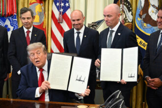 President Donald Trump and Utah Gov. Spencer Cox display executive orders Trump signed to shrink two national monuments in Utah at the Oval Office of the White House on July 13. Credit: Saul Loeb/AFP via Getty Images