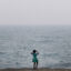 A child looks out over Lake Michigan as smoke from Canadian wildfires blankets the Chicago on July 16. Credit: Scott Olson/Getty Images