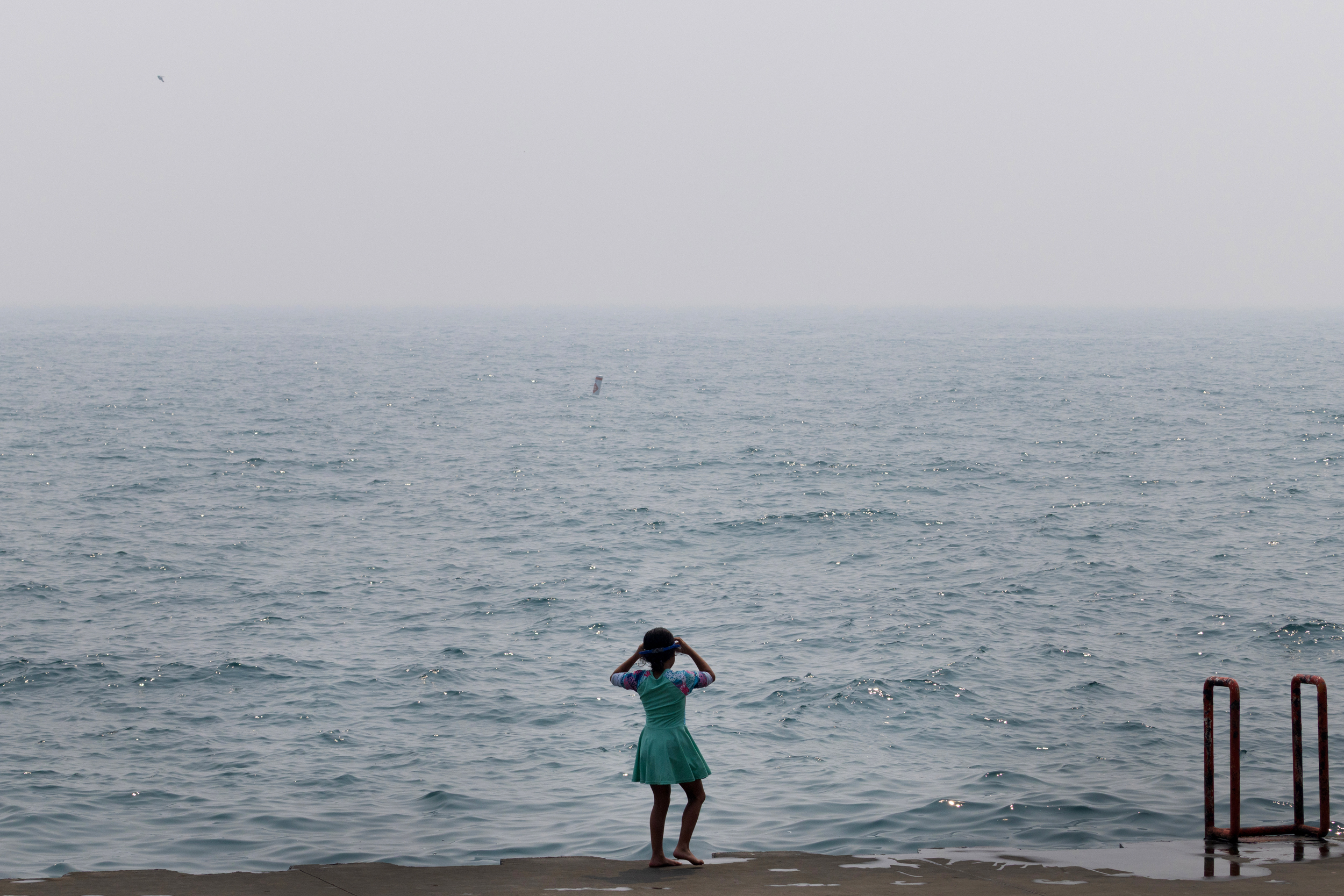 A child looks out over Lake Michigan as smoke from Canadian wildfires blankets the Chicago on July 16. Credit: Scott Olson/Getty Images