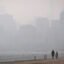 People walk along Lake Michigan as smoke from Canadian wildfires blankets Chicago on Thursday. Credit: Scott Olson/Getty Images