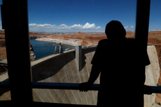 Visitors view the Glen Canyon Dam and Lake Powell from the Carl Hayden Visitor Center on Thursday in Page, Ariz. Credit: Justin Sullivan/Getty Images