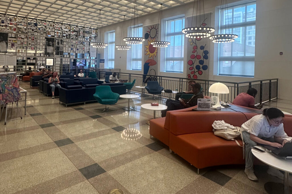 People sit inside Philadelphia’s Parkway Central Library, which serves as one of the city’s cooling centers during heat emergencies. Credit: Daniel Perrin/Inside Climate News