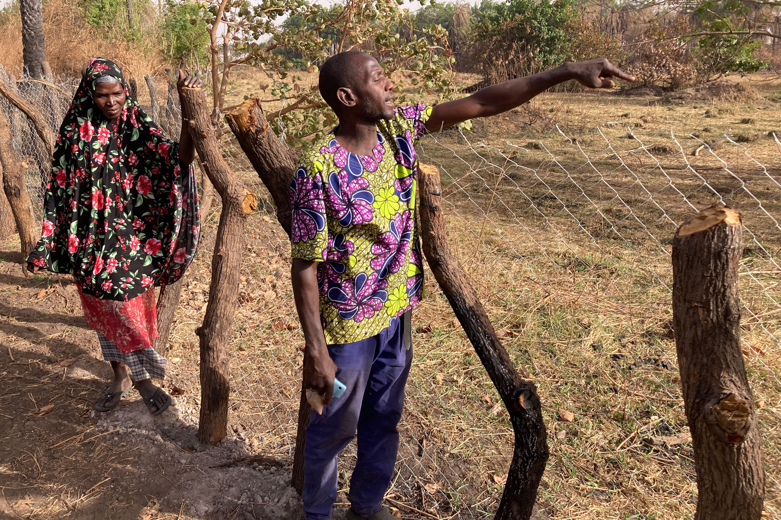 Gambian farmers Ebrima Nyan (right) and Oumie Cham stand by a vegetable field they were forced to abandon five years ago. Credit: Phred Dvorak/Inside Climate News