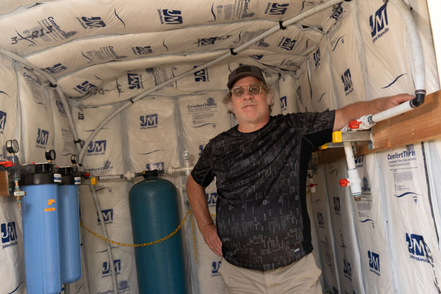 Mike Watters stands in a granular activated carbon filtration system that Chemours was required to give him after his well in Grays Creek was contaminated with several types of PFAS. Credit: Mehmet Demirci/Inside Climate News