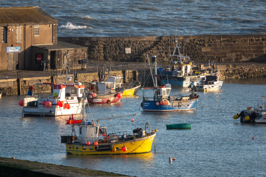 Fishing boats are moored in the harbor on March 2, 2026, in Lyme Regis, England.